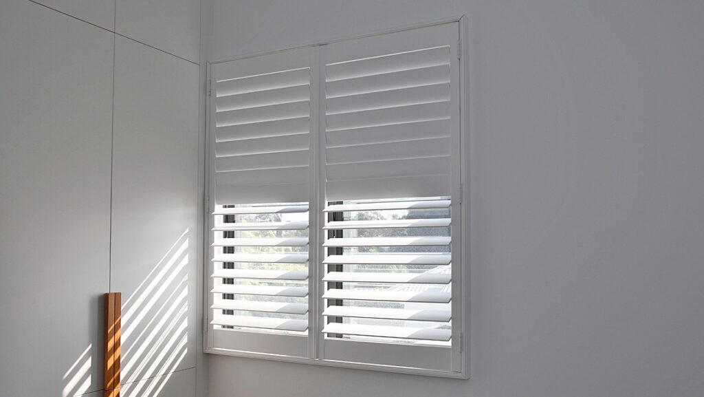 Shutters on window with light filtered through slats
